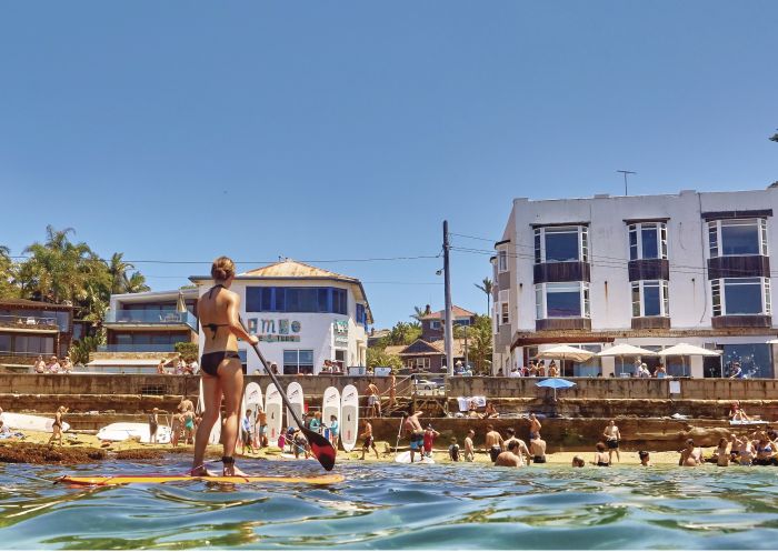 Views of beachgoers and a stand up paddleboarder at Cabbage Tree Bay Aquatic Reserve in Manly Cabbage Tree Bay Aquatic Reserve, Manly