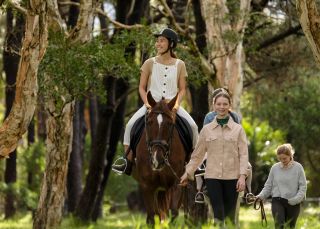 Woman enjoying a horse riding experience with East Side Riding Academy in Centennial Park, Sydney