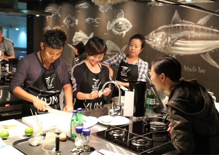 Small group enjoying a cooking class at the Sydney Seafood school, Sydney Fish Market