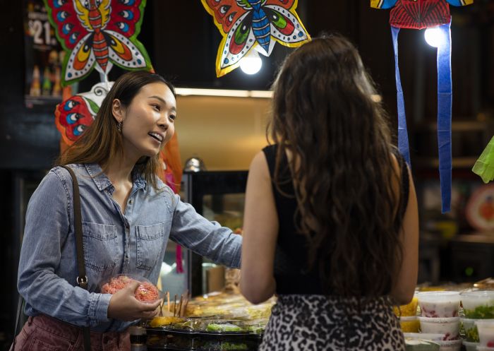 Friends buying Thai street food style desserts from Thanon Khaosan restaurant in Haymarket, Sydney City