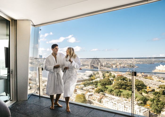 Couple enjoying a coffee and harbour views from their luxurious Crown Towers hotel suite at Crown Sydney in Barangaroo, Sydney City