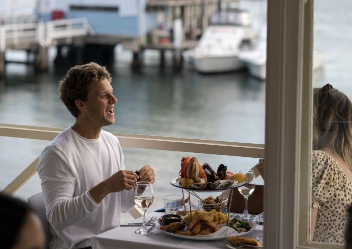 Couple enjoying a seafood platter at Doyles on the Beach Restaurant, Watsons Bay