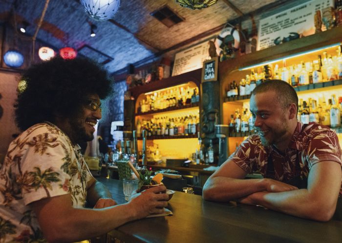 Man enjoying an exotic tiki cocktail made at Jacoby's Tiki Bar on Enmore Road, Enmore in Sydney's inner west