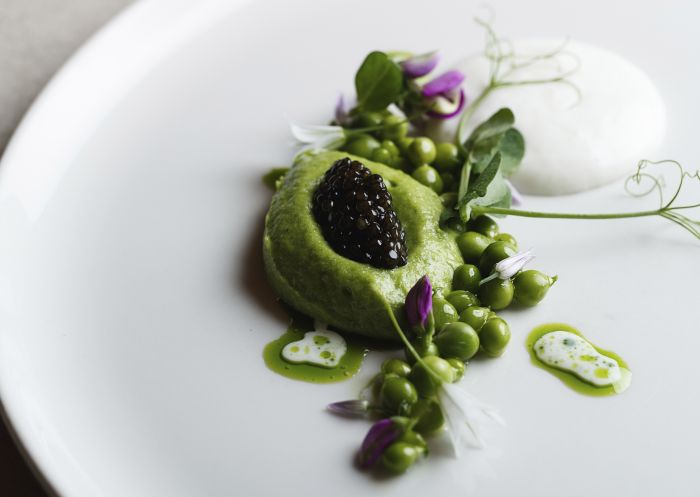 Fine dining dish on the Spring menu at Aria Restaurant, Sydney.  Dish: First of the season asparagus, spring peas, smoked milk and caviar.