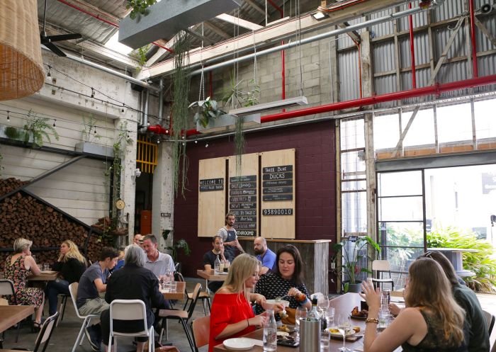 People dining in the courtyard at Three Blue Ducks, Rosebery