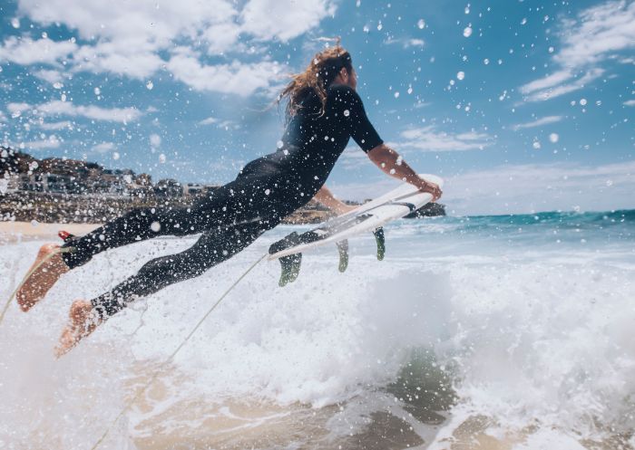 Surfer heading out to catch a wave at Bronte Beach, Sydney