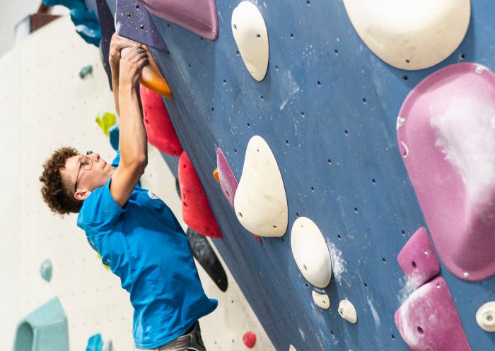 Boy bouldering at 9 Degrees indoor climbing centre, Alexandria