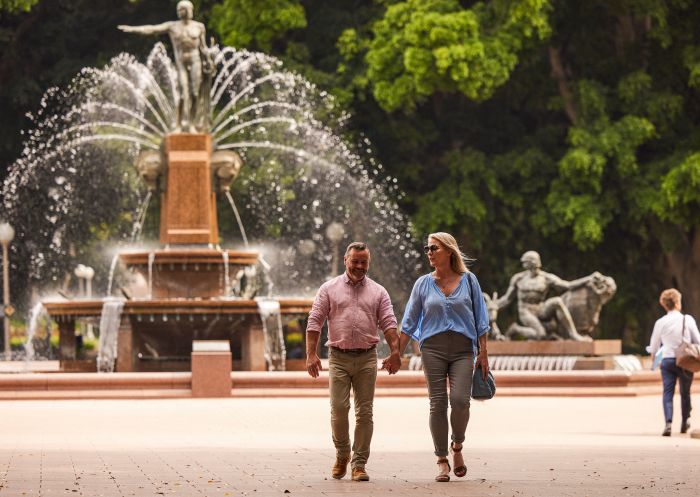 Couple enjoying a walk through Hyde Park near the Archibald Fountain, Sydney