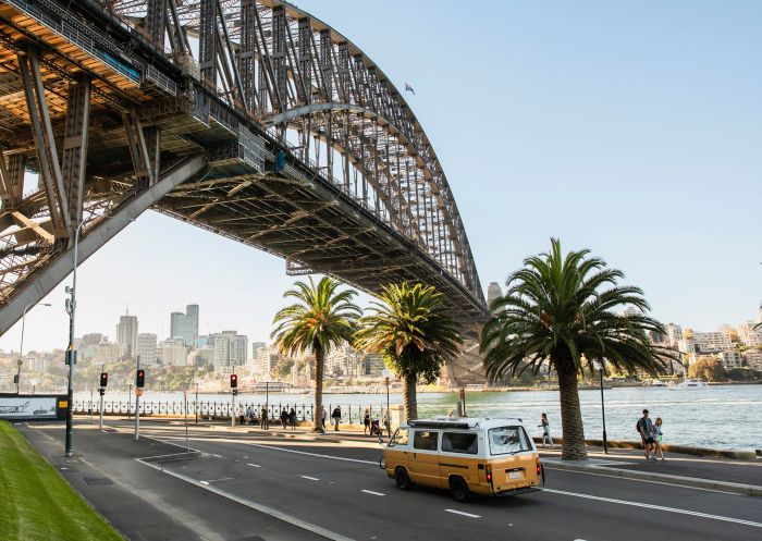  A yellow campervan driving along Hickson Road under the Sydney Harbour Bridge, Sydney