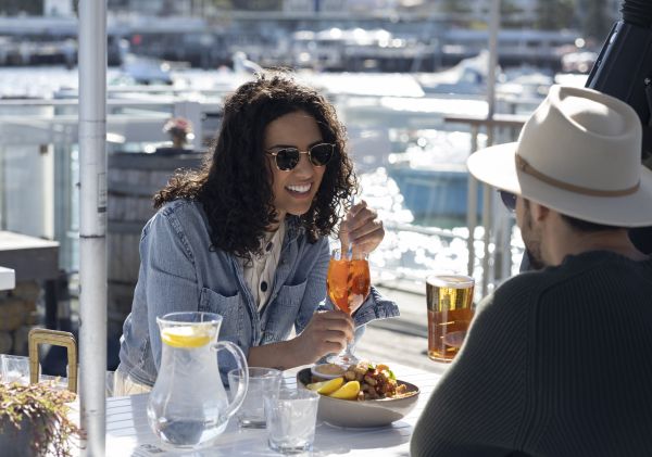 Couple enjoying food and drink at Manly 16ft Skiff Sailing Club, Manly