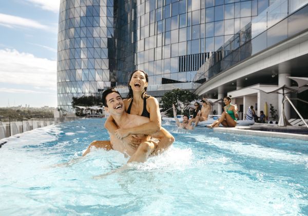 Couple enjoying the luxurious pool at Crown Towers hotel, Crown Sydney, Barangaroo