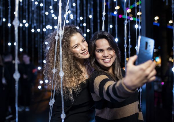 Friends enjoying the Let It Snow light installation in Hickson Road Reserve, The Rocks during Vivid Sydney 2019