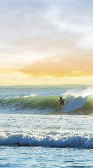 Surfer riding a wave at Manly Beach in Sydney's north