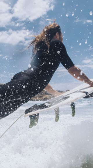 Surfer heading out to catch a wave at Bronte Beach, Sydney