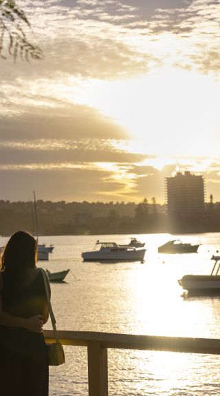 Couple watching the sun setting over North Harbour, Manly