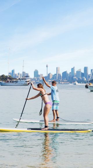 Couple enjoying a morning of stand up paddleboarding at Watsons Bay, Sydney East