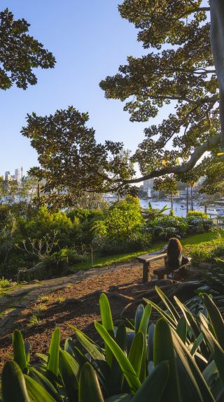 Woman enjoying the serenity in Wendy Whiteley's Secret Garden in Lavender Bay