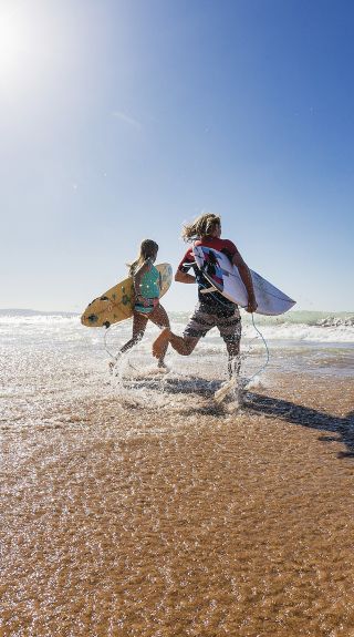 Surfers heading out to enjoy the morning waves, Palm Beach