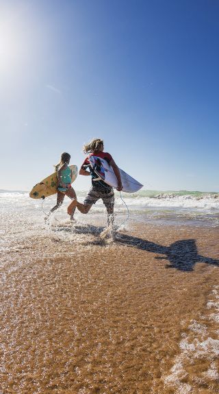 Surfers heading out to enjoy the morning waves, Palm Beach