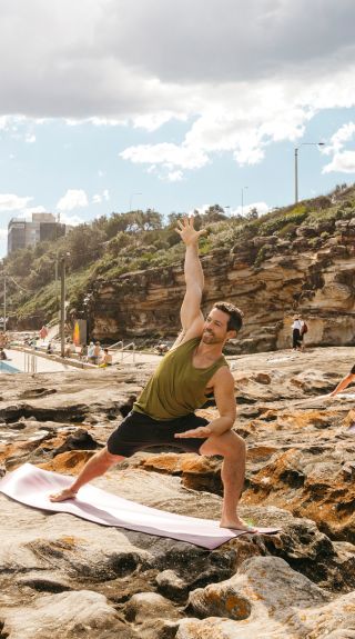 Group enjoying a yoga session by the ocean, Freshwater Beach