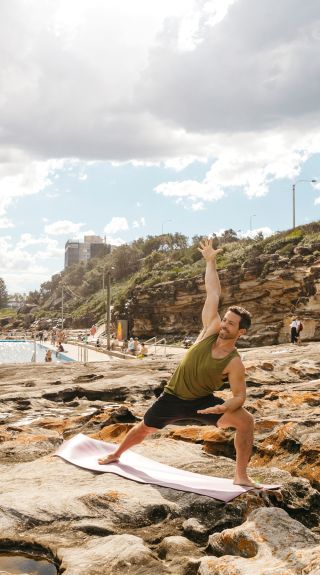 Group enjoying a yoga session by the ocean, Freshwater Beach