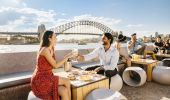 Couple enjoying food and drink with harbour views at Opera Bar, Sydney