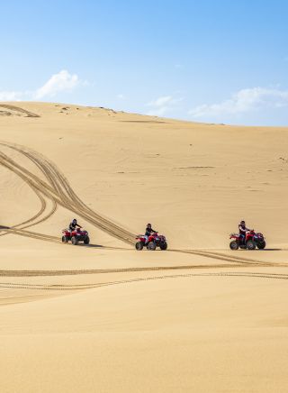 Small group enjoying an Aboriginal cultural tour on quad bikes with Sand Dune Adventures, Port Stephens