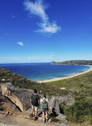 Couple enjoying a scenic coastal hike on the Barrenjoey Lighthouse Walk in Palm Beach, Sydney