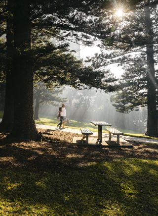 Couple walking through the sunlit Cronulla Park, Cronulla