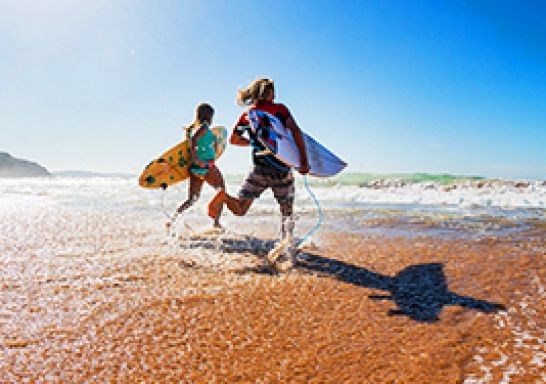 Two surfers running in at Palm Beach, Northern Beaches